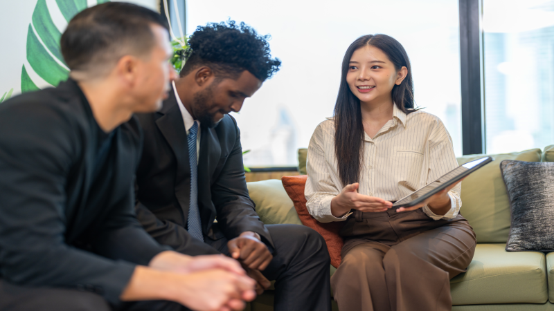 Businesswoman insurance agent presenting health or auto insurance policy details to businessmen, risk assessment and coverage consultation, financial planning, protection, security and investment
