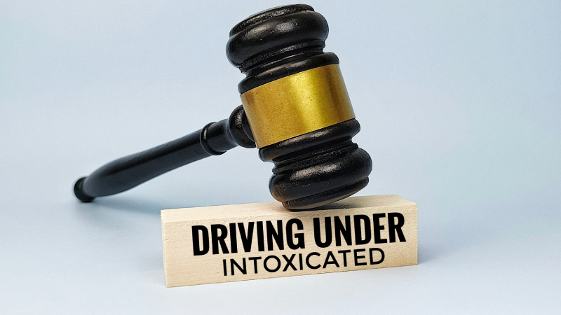 Judge gavel on wooden block with text driving under intoxication representing DUI law enforcement penalty traffic violation and legal consequences concept.