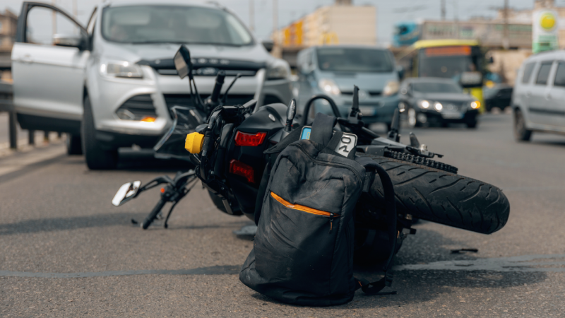 The motorcycle lies on the sidewalk after a ride. Serious accident. Accident, close-up. Lost control and fell. Driving hazards. Collisions with another vehicle.