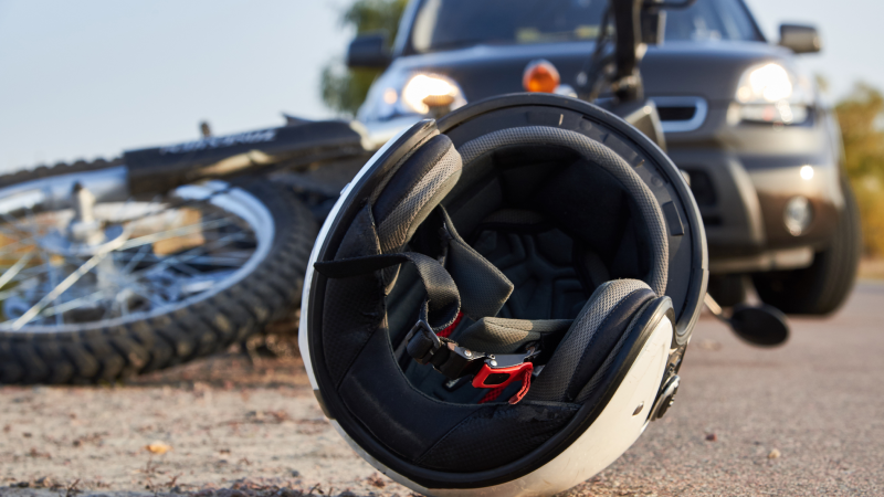 Photo of car, helmet and motorcycle on road, the concept of road accidents.