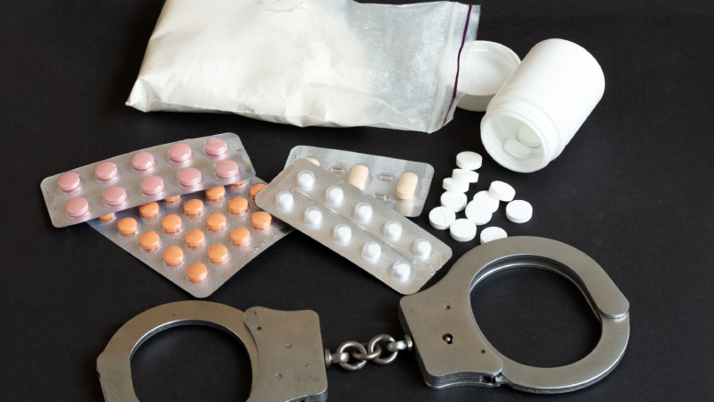 Drugs and handcuffs composition. Selective focus. Crime concept. Illegal money