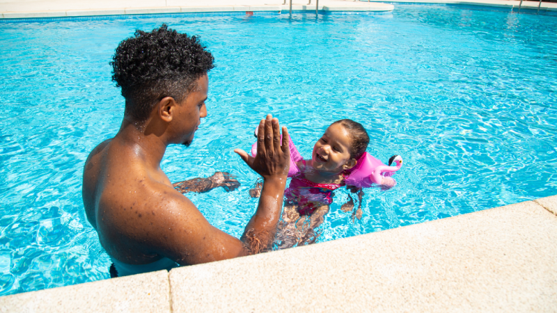 Father and daughter having fun in pool
