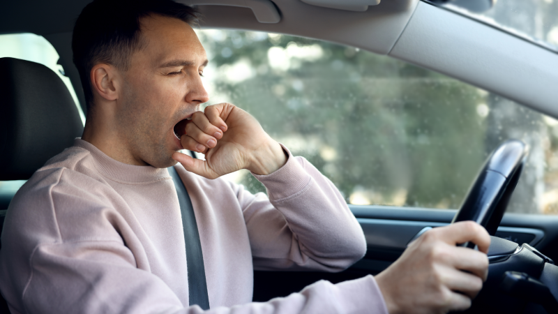 Sleepy driver yawning in his modern car
