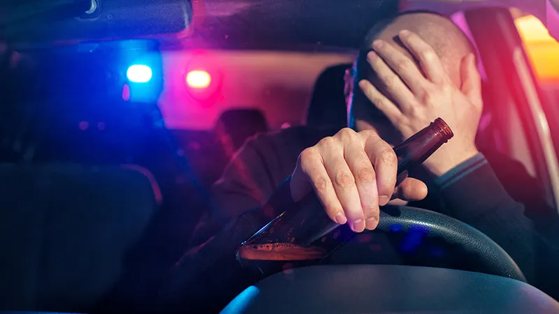 Upset male driver is caught driving under alcohol influence.