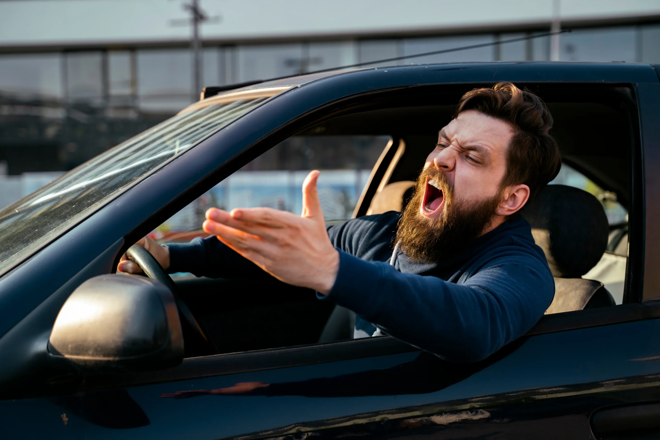 Bearded young man road raging , yelling from the car