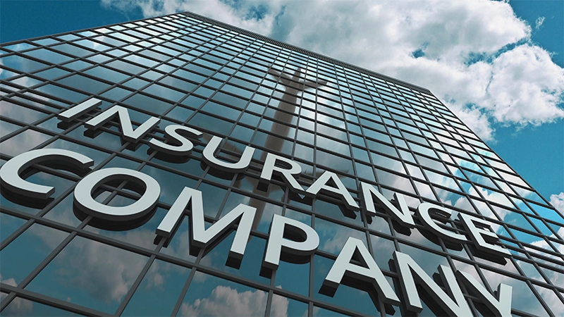 INSURANCE COMPANY signboard on a modern skyscraper reflecting flying airplane.