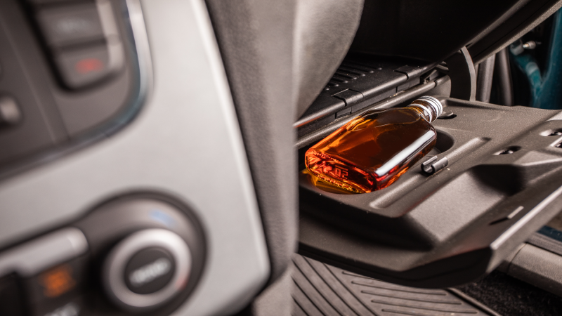 Drink and drive. Bottle of alcohol inside the car. Don't Drink for Drive