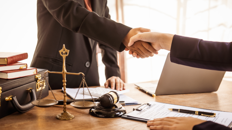 Shaking hands, Lawyers offer legal guidance, stand for clients in court, and aid with legal paperwork. analyze laws to safeguard clients' rights and interests, fair representation and justice.
