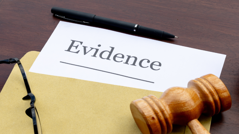 Evidence Document Emerging from Envelope with Gavel on Desk